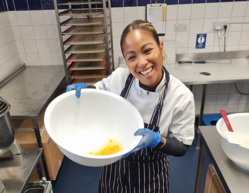 Frieda holding bowl of eggs in Moving Venue Kithcen